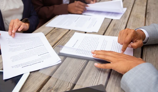 Pessoas analisando documentos em uma mesa