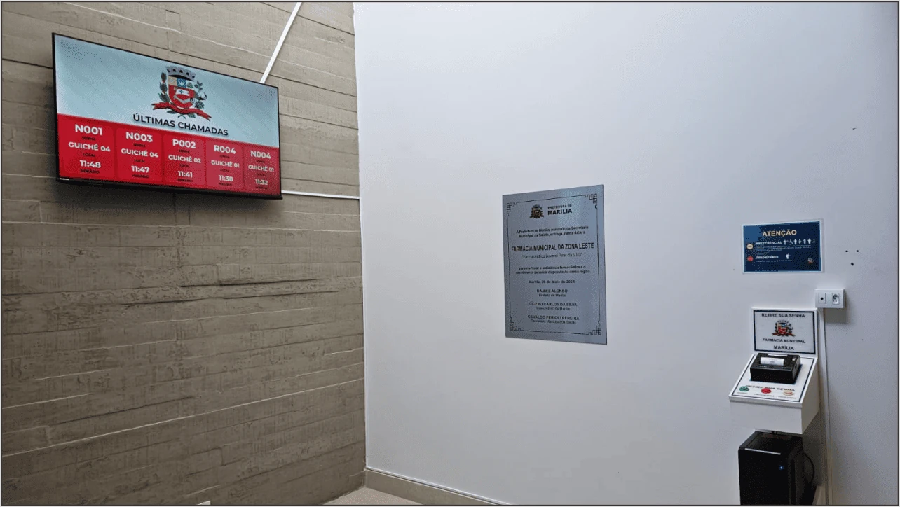 Ambiente de saúde com televisão exibindo histórico de senhas